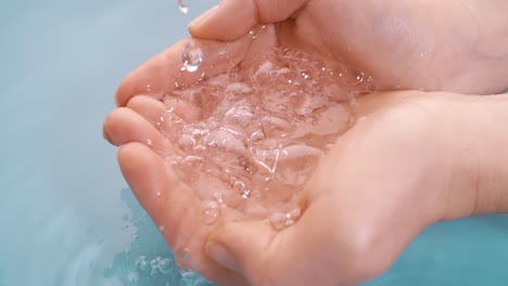 clean drinking water flows in the palms of the woman hands. shot on super slow motion camera 1000 fps.