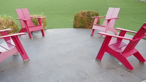 four red chairs in a circle on a patio