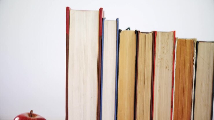 mela e libri disposti su un tavolo di legno 4k