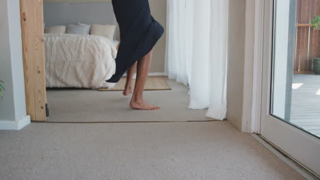 happy woman jumping on bed in hotel room having fun successful lifestyle celebrating enjoying luxury penthouse apartment