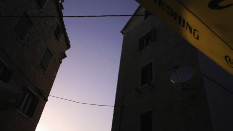 Sunset-seen-through-buildings-by-a-restaurant-in-the-old-town-of-Split-in-Croatia