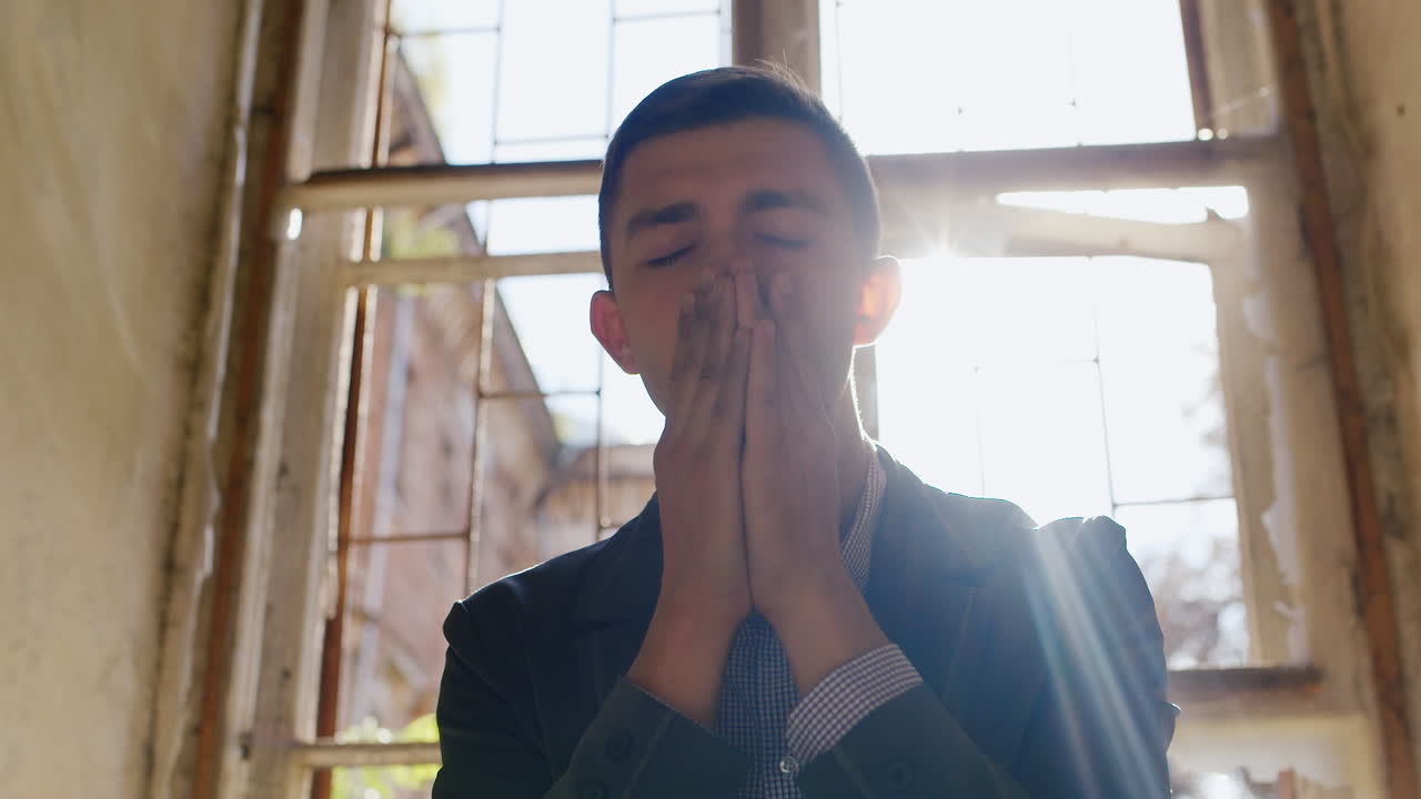 joven empresario infeliz sentado en el alféizar de la ventana decepcionado