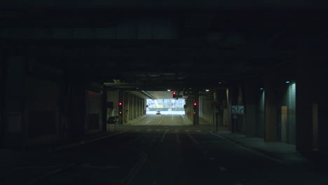 navigating a dark urban tunnel with red traffic lights