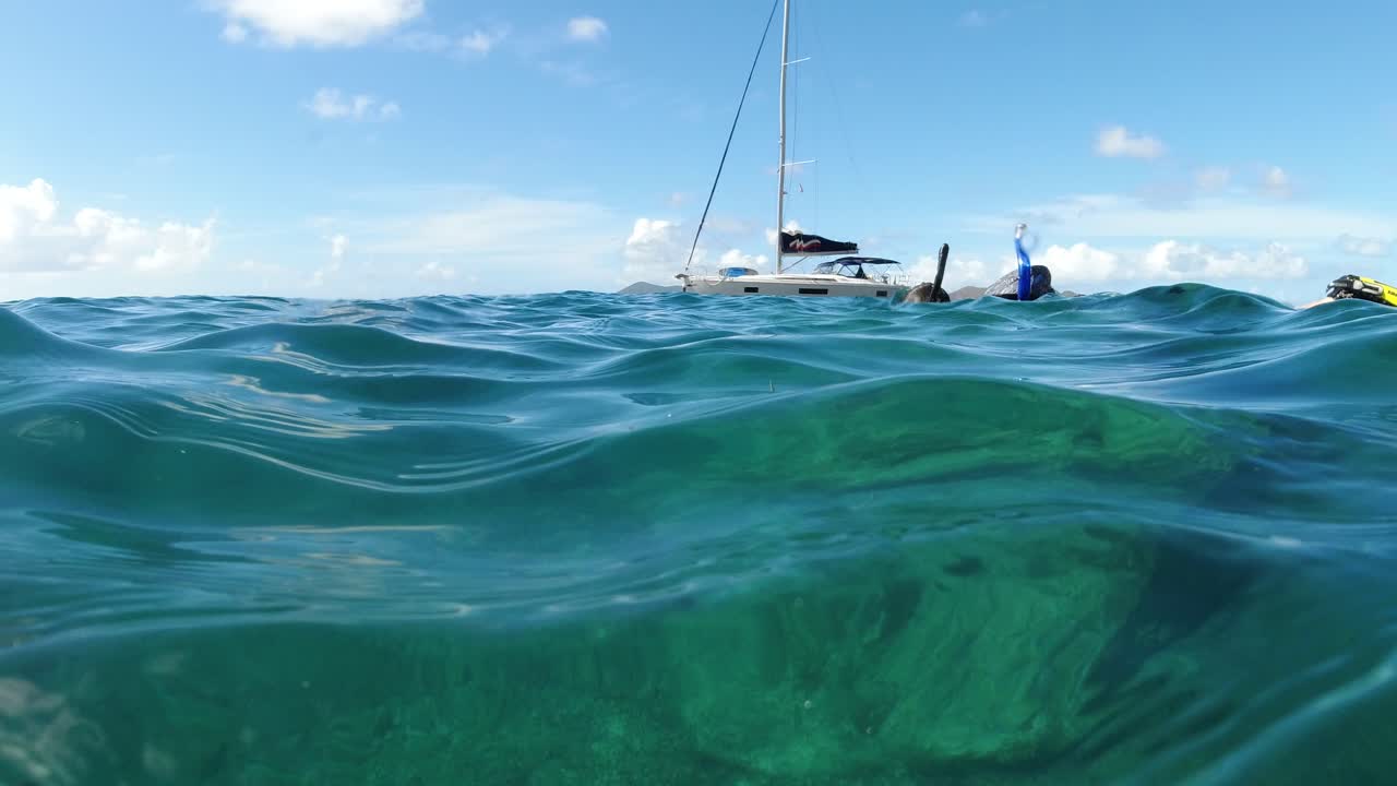 mujer buceando nadando por la lente de vista de burbuja dividida en las islas vírgenes británicas