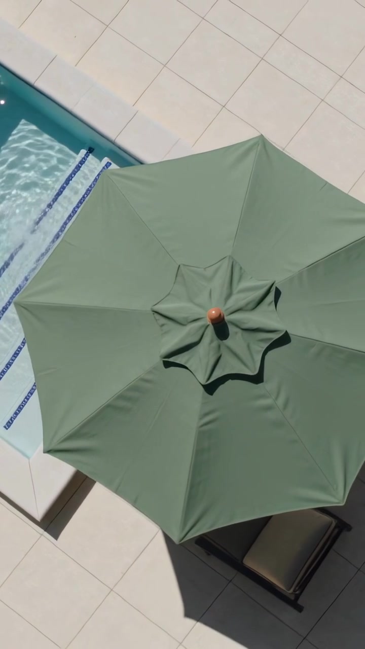 Video verticale: Telecamera panoramica che rivela un ombrellone ottagonale verde a bordo piscina, mostrando i segnali delle corsie.