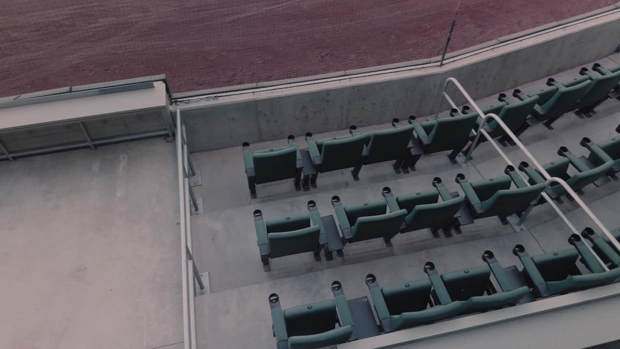 Jævn panorering fra venstre mod højre over tomme nederste stadionpladser ved siden af en baseballbane.