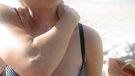 a young woman rubs her neck with sunscreen