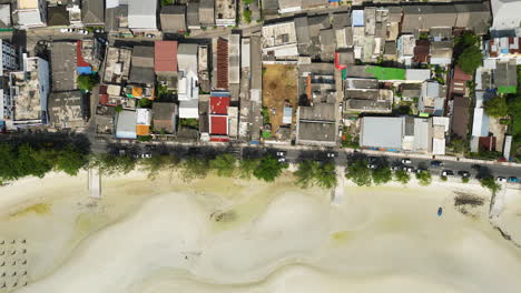 Aerial-top-down-shot-showing-roofs-of-buildings-beside-sandy-beach-in-Nathon-Town-on-Koh-Samui-Island