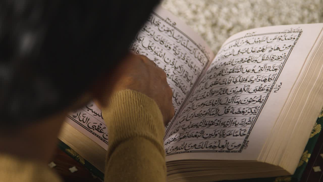 cerca de un hombre musulmán en casa sentado en el suelo y recitando el corán 2