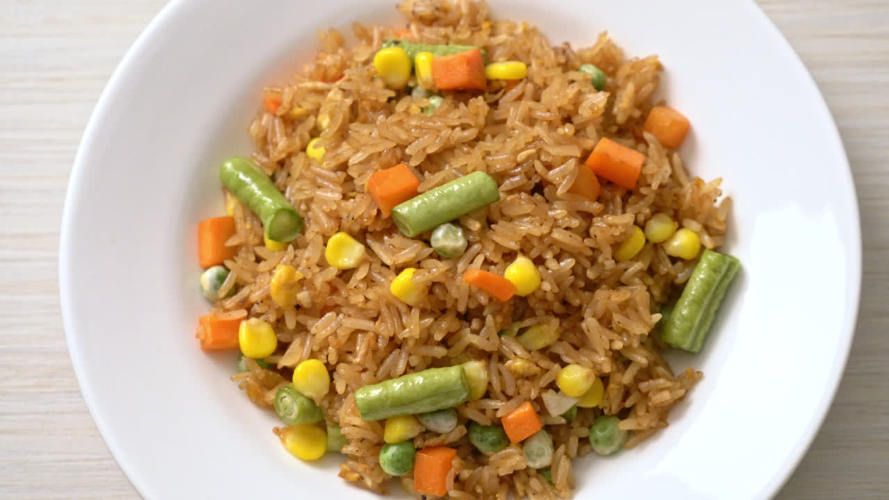 arroz frito con guisantes, zanahoria y maíz - estilo de comida vegetariana y saludable