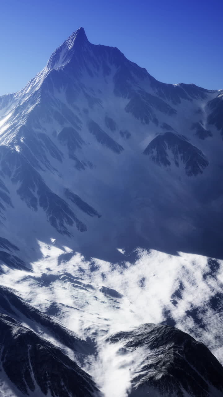 Panorama montano innevato con cielo sereno e ombre sui pendii di giorno.
