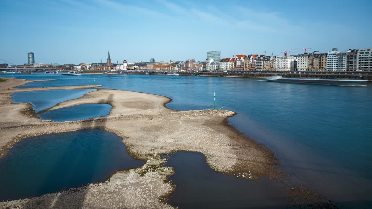Dusseldorf, Germany. View over Rhine river towards Rhine promenade on sunny day in early spring, wide angle time lapse