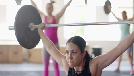 Determined-unaltered-biracial-woman-free-weight-training-at-gym-lifting-barbell,-in-slow-motion