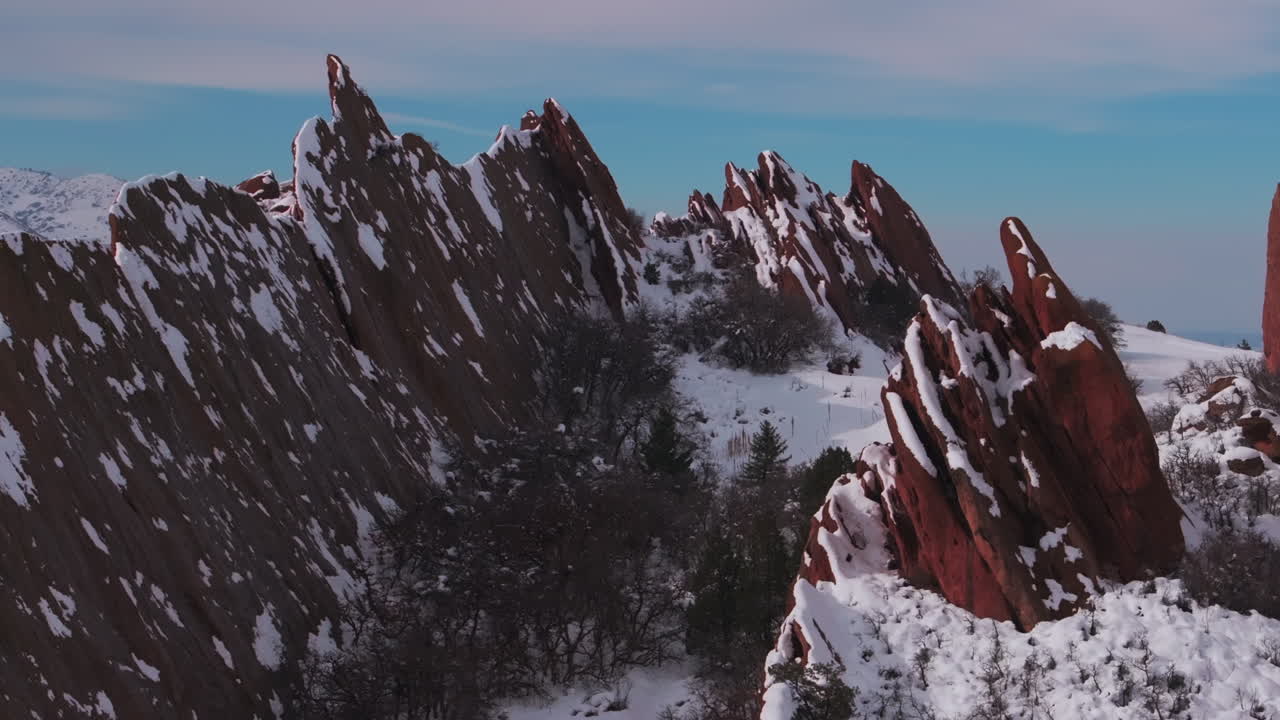 campo de golf del parque estatal de roxboro drone aéreo colorado frente rango después del invierno primavera profundo polvo nieve fresca en dramáticas rocas rojas afiladas paisaje de montaña littleton denver movimiento de jib hacia arriba