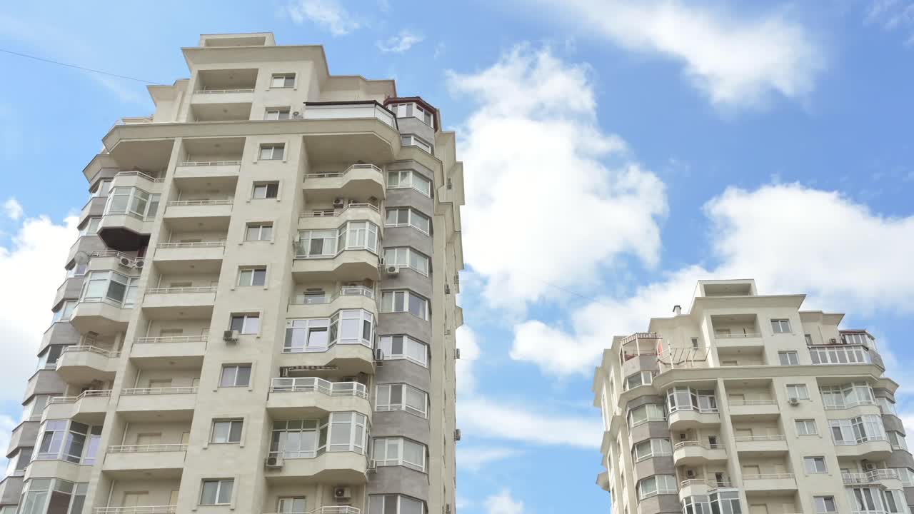 Low angle view of two white buildings with the sky on the background