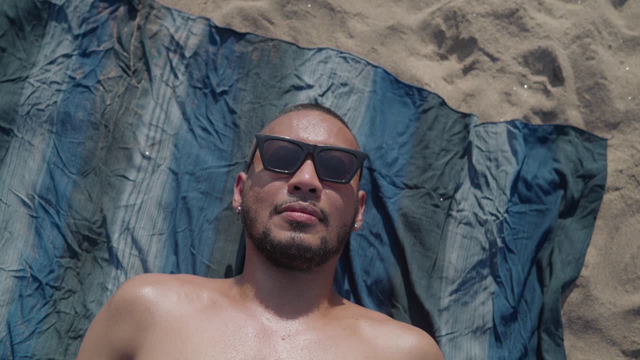 hombre tomando el sol en la playa