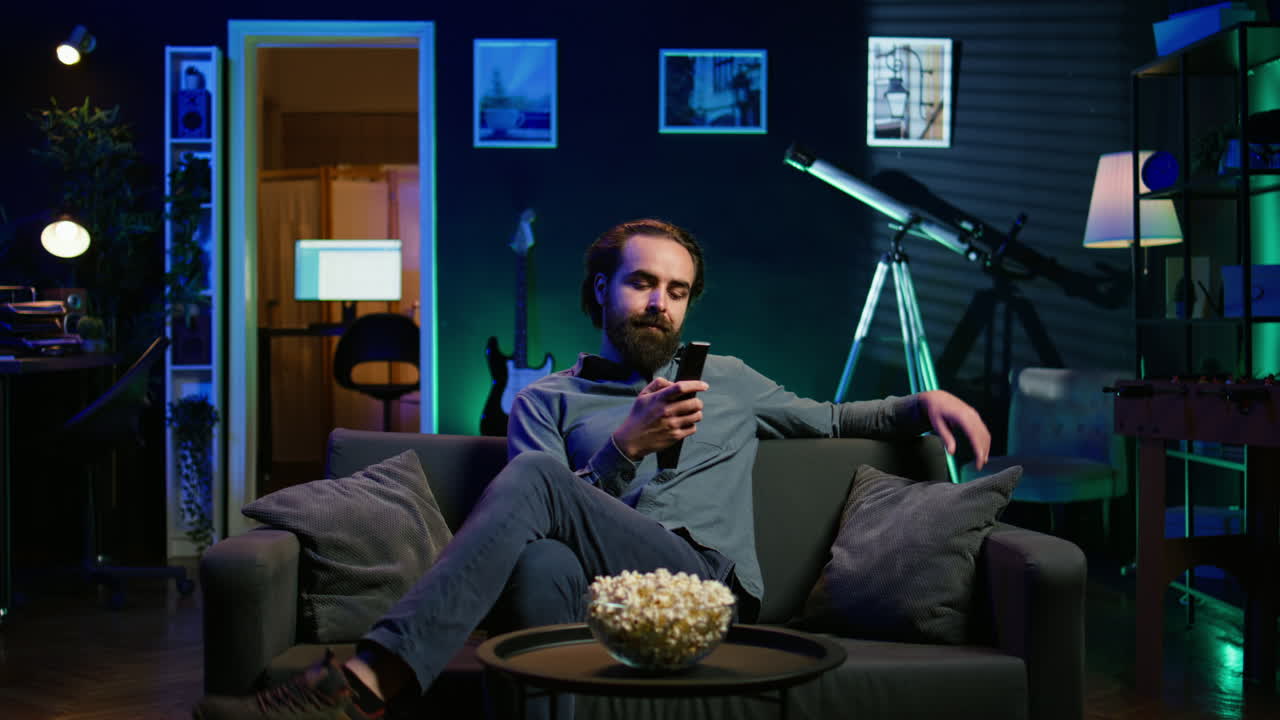 영화 를 즐기기 위해 소파 에 앉아 있는 아파트 에 도착 한 사람