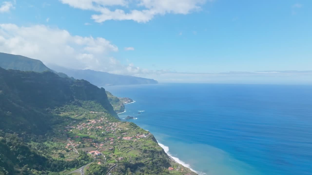 Carrellata aerea su una donna che ammira splendidi campi terrazzati sulla costa di Madeira, Portogallo