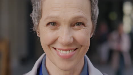 portrait of mature business woman smiling outdoors in urban city scene