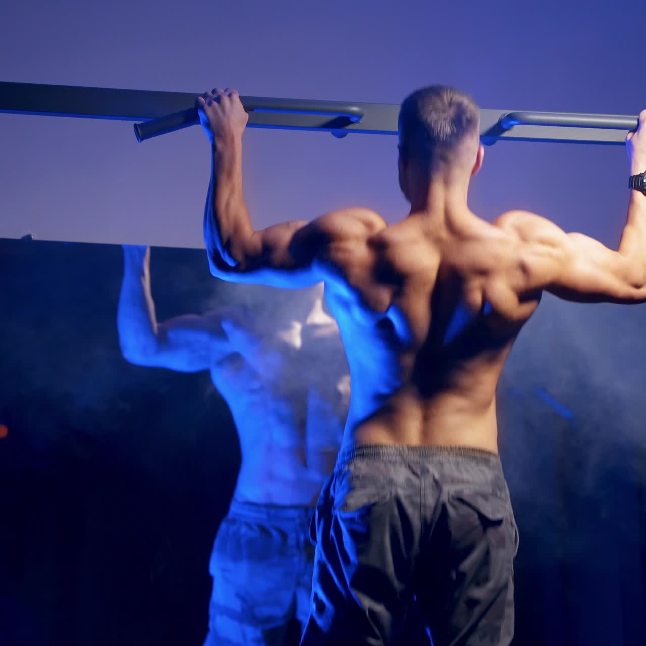 Schiena muscolosa di giovane bodybuilder in allenamento