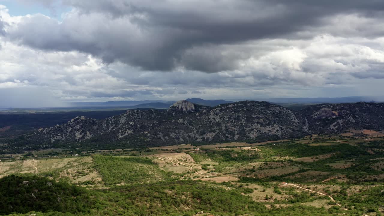 dron aéreo a la izquierda de un camión plano amplio extremo de la cordillera de la pedra de sao pedro en sítio novo, brasil en el estado de rio grande do norte durante un nublado y tormentoso día de verano