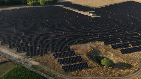 Antena-De-Una-Granja-De-Paneles-Solares-En-Un-Campo-Remoto-Con-Tierras-Agrícolas,-Suministro-Eléctrico-De-Energía-Verde