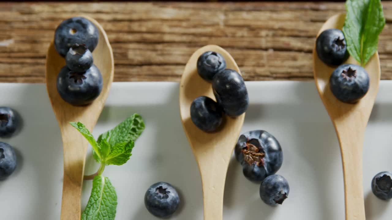 Spoons of blueberries with mint arranged on tray table 4k