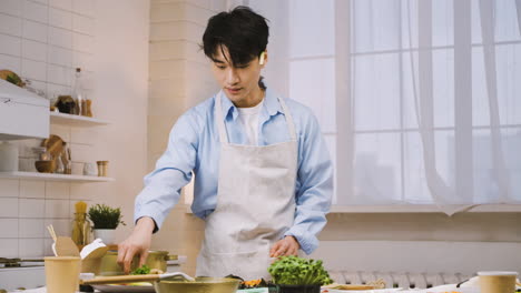 japanese man wearing appron and cutting ingredients in the kitchen