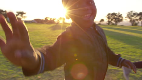 Elementary-school-kids-running-and-waving-to-camera-outdoors