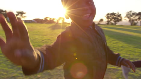 elementary school kids running and waving to camera outdoors