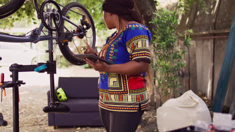 female using tablet for bike maintenance