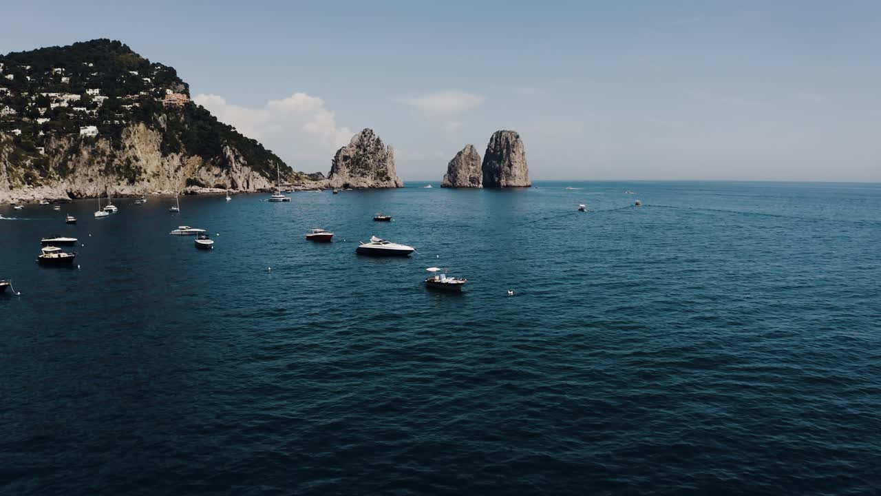 Drone shot over Capri, Italy's calm water with boats parked for the day