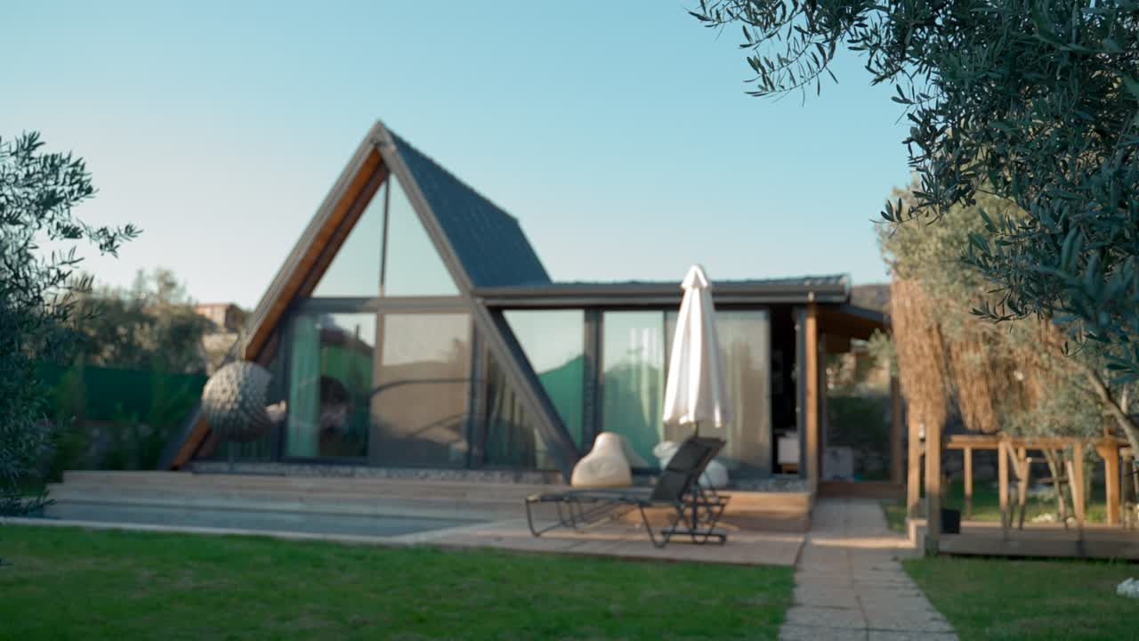 una mujer muestra las llaves de una nueva casa de lujo entrando en el patio.