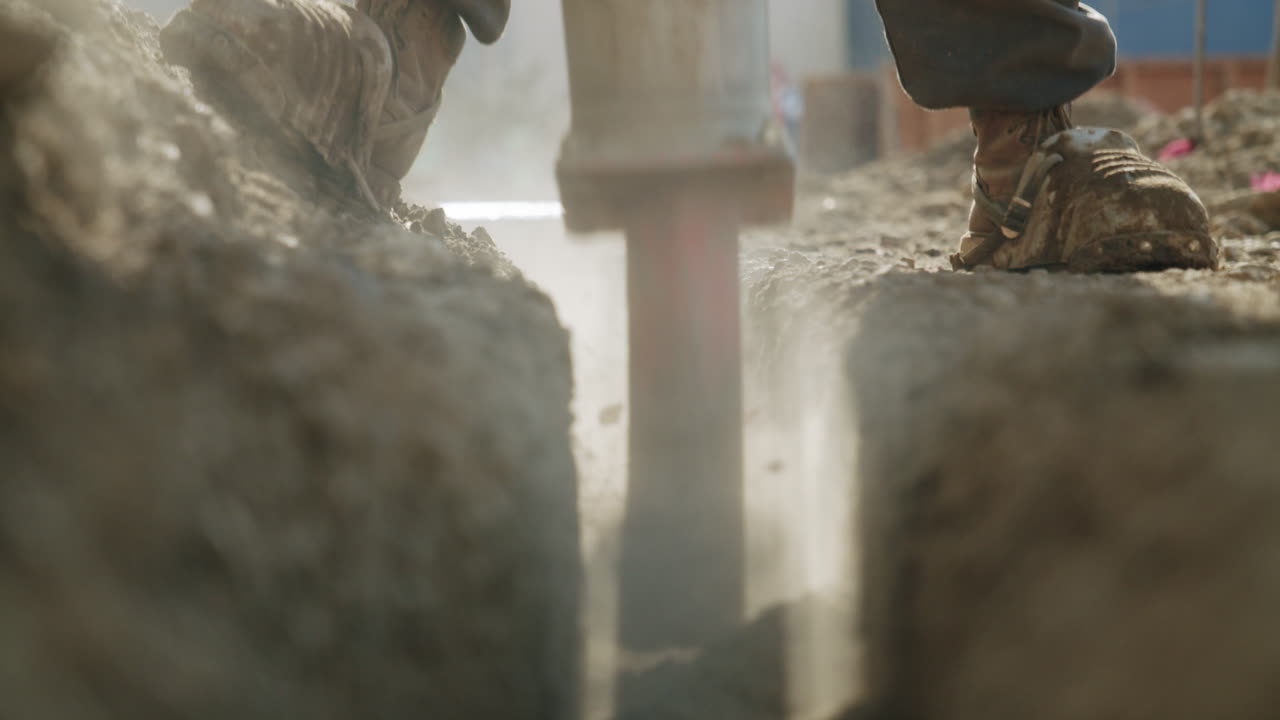 Close-up of a Worker Digging a Trench with a Jackhammer
