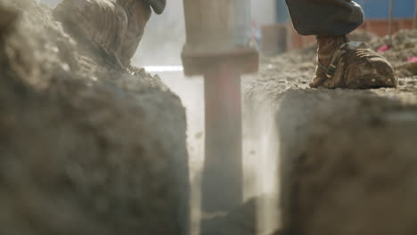 close-up of a worker digging a trench with a jackhammer