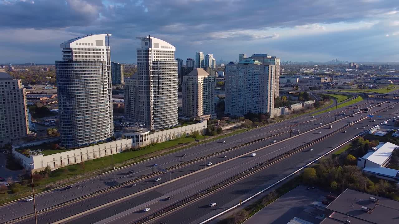 edificios de apartamentos en condominio residencial a lo largo de la autopista 401 en toronto, ontario, con mucho tráfico y camiones de transporte