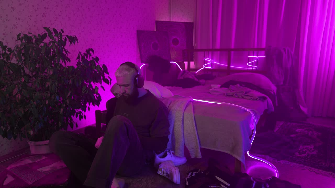 человек слушает музыку в фиолетовой неоновой освещенной спальне