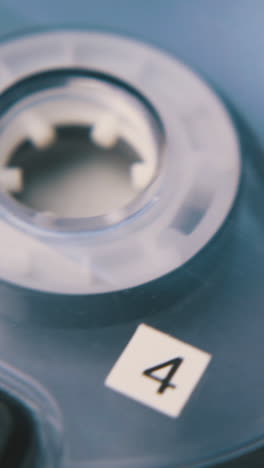vintage compact cassette with magnetic tape in black case on white background extreme close view