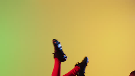 african american male rugby player jumping with rugby ball over yellow lighting