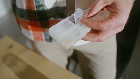 person taking pills from a daily pill organizer