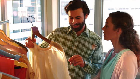 pareja seleccionando un vestido mientras compran ropa