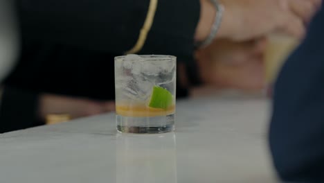 Klassischer-Caipirinha-Cocktail-Auf-Einer-Bartheke-Mit-Limette-Und-Eis,-Der-Erfrischende-Vibes-Einfängt