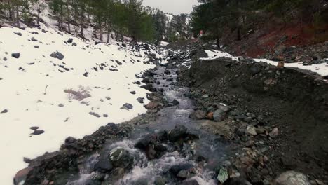 drone shots of stream and small waterfalls created by melting snow in troodos mountain cyprus