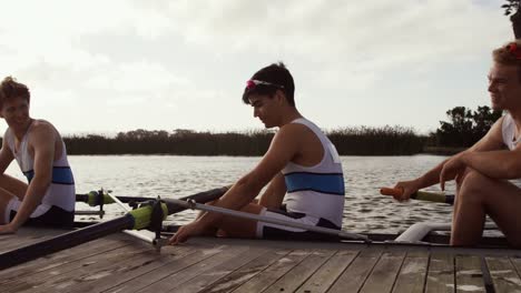 male rowers laughing on the boat after practice