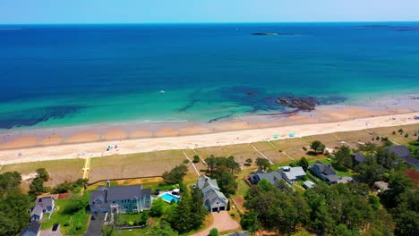 aerial video of a maine beach house getaway. prime real estate with sunny deck, oceanfront patio, and yard by the atlantic waves. perfect coastal property for peaceful family vacations