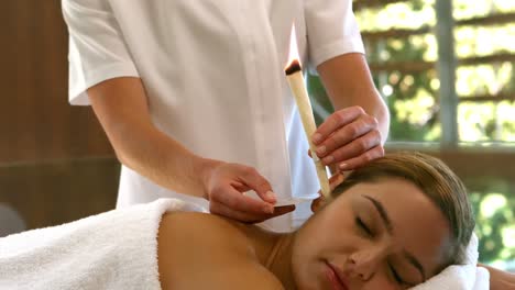 Beautiful-woman-receiving-ear-candle-treatment-