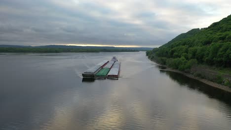 barge and tugboat on river with forest background