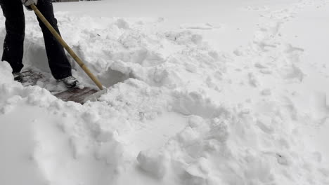 a girl using a snowpusher to frees the sidewalk from snow in germany - slow motion