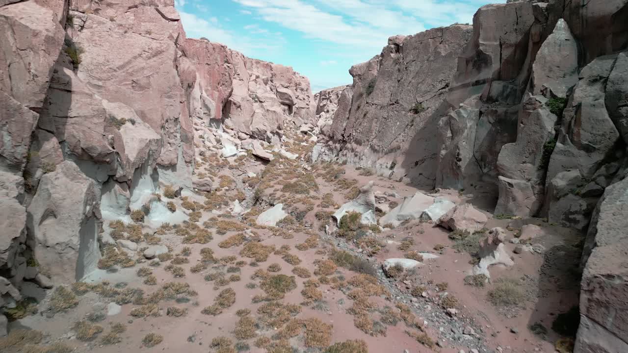 drone pasando cerca del suelo de un pequeño cañón en el desierto chileno