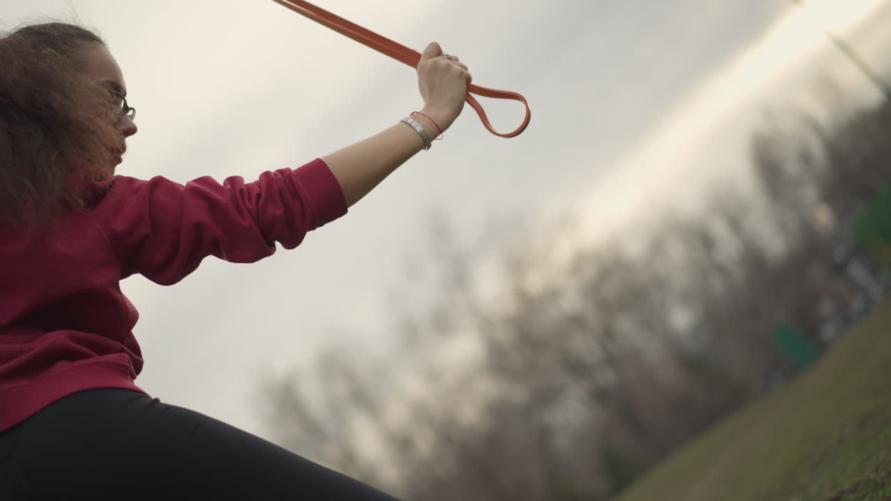Yoga Instructor In Park, Serene Woman Lifts Arms Upward Outdoors, Empowered Female Figure Engages In Dance Under Cloudy Sky, Graceful Woman In Park Strikes Uplifting Pose Amid Overcast Weather